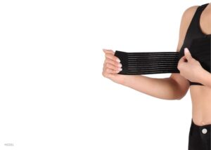 Woman fastening black compression bra around her breasts.