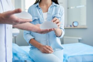 Woman touching a silicone breast implant in a doctor's office