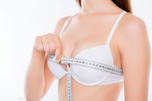 Women measuring her breasts.