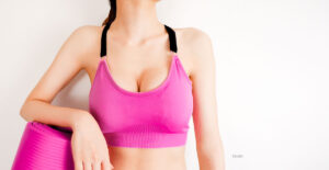 Woman in pink sports bra with pink yoga mat